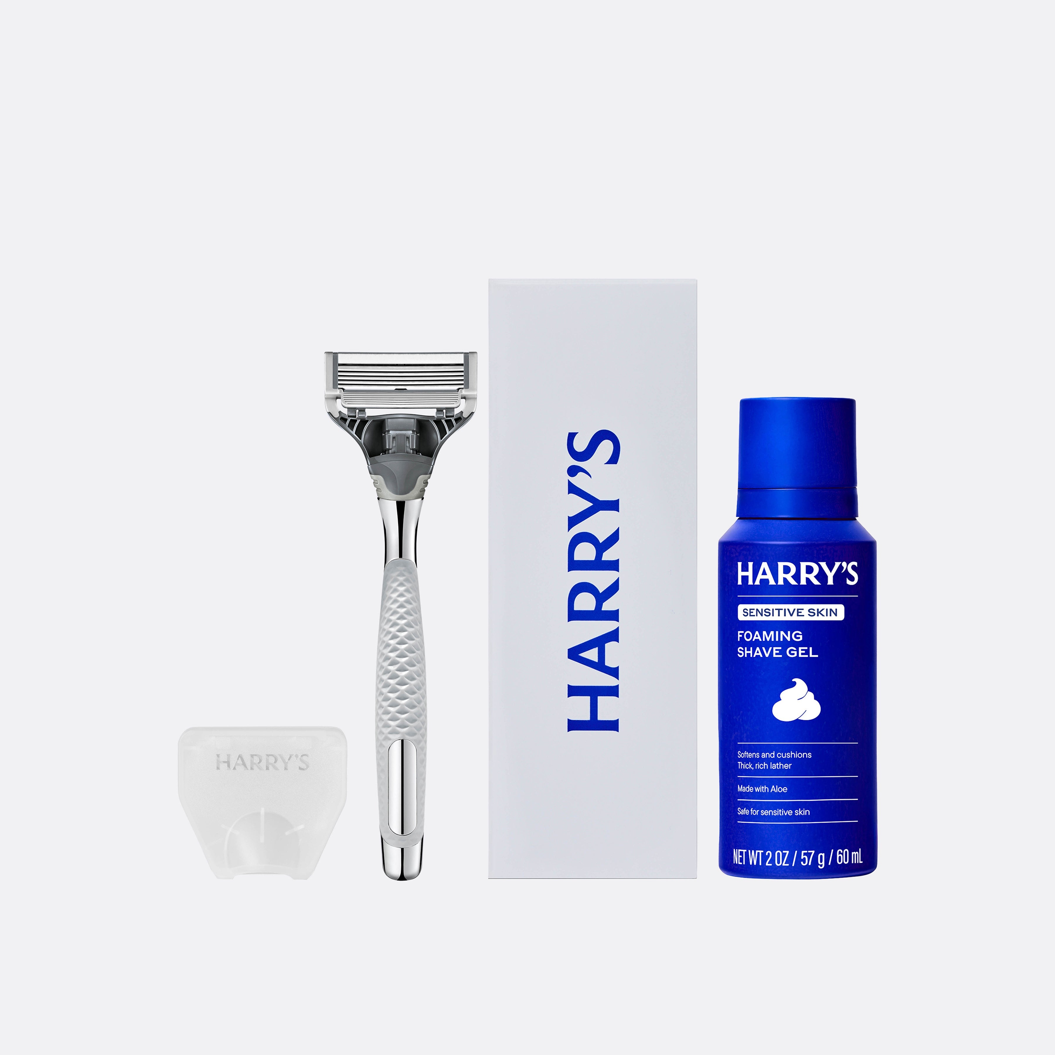 Harry's grooming kit with razor, shaving gel, and brush on a white background